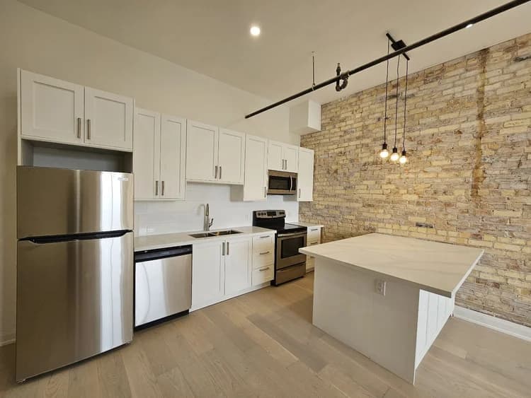 Finished kitchen with exposed brick.
